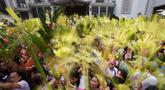 Para umat Kristiani mengacungkan daun palem mereka selama upacara pemberkatan di luar Katedral Antipolo, kota Antipolo, provinsi Rizal, Filipina, saat memperingati Minggu Palma, 29 Maret 2026. (AP Photo/Aaron Favila)