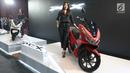 Seorang wanita berdiri di samping skutik all new Honda PCX saat peluncurannya di Jakarta, Rabu (7/2). Menurut Vice Presiden PT AHM Johannes Loman, all new PCX diciptakan karena banyaknya pecinta skutik premium di Tanah Air. (Liputan6.com/Angga Yuniar)