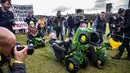 Para petani dari Groningen naik traktor mainan saat demonstrasi melawan fracking di Den Haag, Belanda (1/1). Pemerintah Belanda sedang melakukan persidangan melawan fracking di Groningen pada bulan Februari. (AFP Photo/ANP/Siese Veenstra/Netherlands Out)