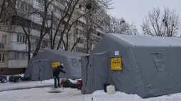 Serangan itu dilaporkan menggempur jaringan listrik di sejumlah wilayah, termasuk kawasan ibu kota Kiev, saat Ukraina dilanda musim dingin. Tampak dalam foto, seorang pria menghangatkan diri di tenda-tenda darurat tempat orang-orang dapat menghangatkan diri setelah serangan udara rutin Rusia terhadap fasilitas energi negara itu di tengah musim dingin, Kyiv, Ukraina, Selasa 13 Januari 2026. (AP Photo/Efrem Lukatsky)