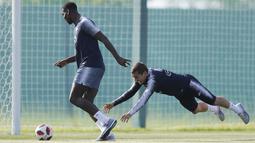 Paul Pogba (kiri) mengecoh Antoine Griezmann saat sesi latihan di Glebovets, Rusia, (12/7/2018). Latihan tersebut sebagai persiapan Prancis melawan Kroasia pada Final Piala Dunia 2018. (AP/David Vincent)