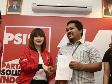 Ketua Umum PSI Grace Natalie (dua kiri) bersalaman dengan penyebar foto hoax dan fitnah terhadap dirinya, Taufan Pratama di Jakarta, Senin (19/11). Taufan Pratama meminta maaf langsung kepada Grace Natalie. (Liputan6.com/Herman Zakharia)