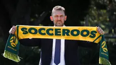 Tony Popovic, pelatih kepala yang baru ditunjuk untuk tim sepak bola nasional Australia, berpose dengan syal setelah konferensi pers di Sydney pada 23 September 2024. (DAVID GRAY/AFP)