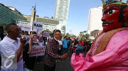 Relawan yang mengenakan topeng Ahok memberikan bunga kepada ondel-ondel saat melakukan aksi kampanye pilkada damai, aman dan sportif di CFD, kawasan Bunderan HI, Jakarta, Minggu (30/10). (Liputan6.com/Johan Tallo)