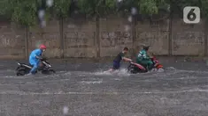 Pengendara terjebak banjir yang menggenangi jalan Bayangkara Pusdiklat, Kota Tangerang Selatan, Banten, Selasa (2/11/2021). BMKG mengeluarkan peringatan potensi cuaca ekstrem di wilayah Jakarta, Bogor, Depok, Tangerang, dan Bekasi (Jabodetabek). (Liputan6.com/Angga Yuniar)