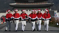 Anak-anak Korea Selatan mengenakan pakaian Santa Claus berjalan di depan Istana Gyeongbokgung, Seoul, Jumat (30/11). Anak-anak tersebut bersiap meluncurkan kampanye penggalangan dana akhir tahun dari The Salvation Army. (Jung Yeon-je/AFP)