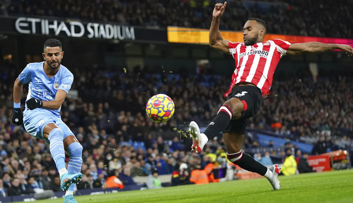 Pemain Brentford Rico Henry (kanan) berebut bola dengan pemain Manchester City Riyad Mahrez pada pertandingan sepak bola Liga Inggris di City of Manchester Stadium, Manchester, Inggris, 9 Februari 2022. Manchester City menang 2-0. (AP Photo/Jon Super)