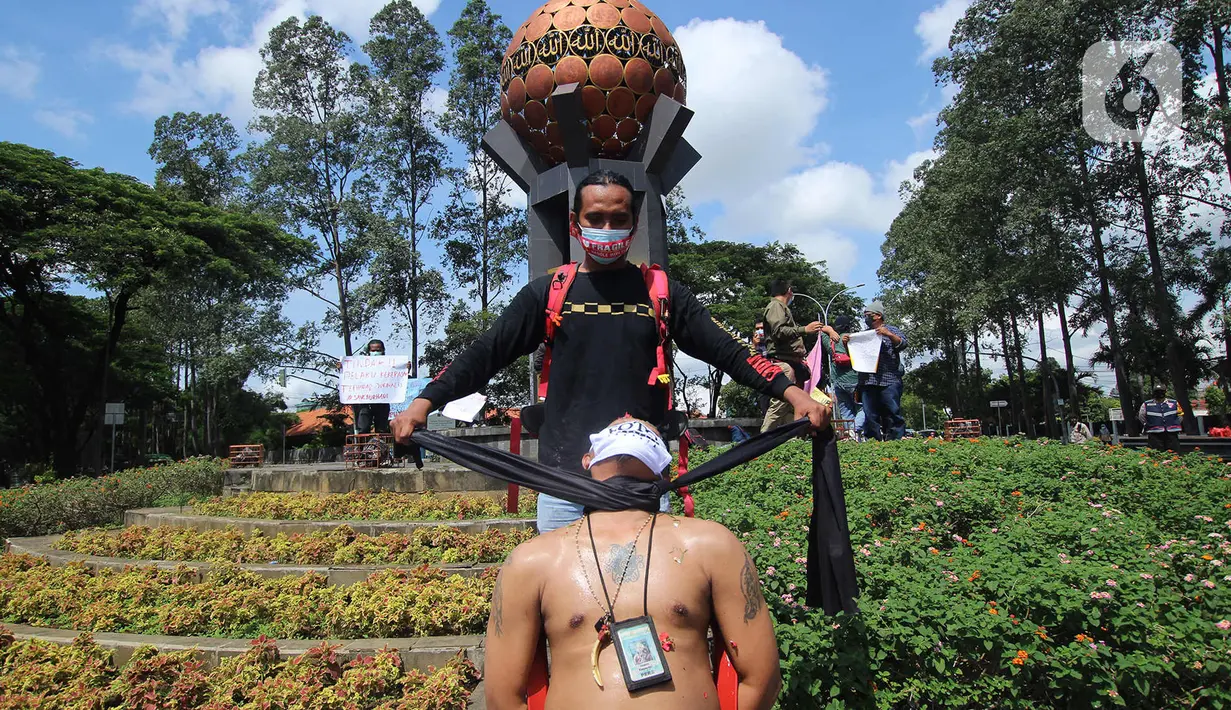 Seorang jurnalis melakukan aksi teatrikal saat aksi solidaritas di kawasan Tugu Adipura, Kota Tangerang, Rabu (31/3/2021). Mereka menuntut pihak berwenang mengusut tuntas oknum pelaku kekerasan terhadap wartawan Tempo, Nurhadi dan kasus kekerasan jurnalis lainnya. (Liputan6.com/Angga Yuniar)