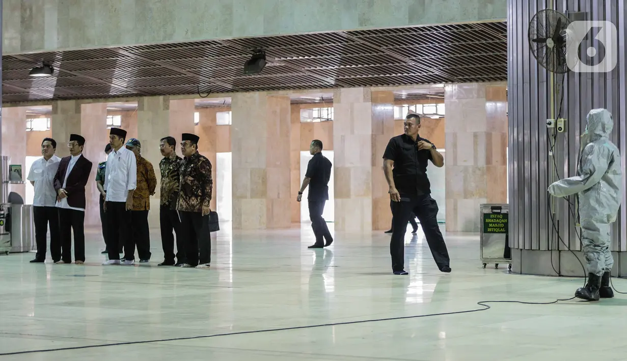 Presiden Joko Widodo atau Jokowi didampingi sejumlah menteri menyaksikan petugas menyemprotkan cairan disinfektan di Masjid Istiqlal, Jakarta, Jumat (13/3/2020). Proses sterilisasi dilakukan dalam rangka mencegah penularan virus corona Covid-19. (Liputan6.com/Faizal Fanani)