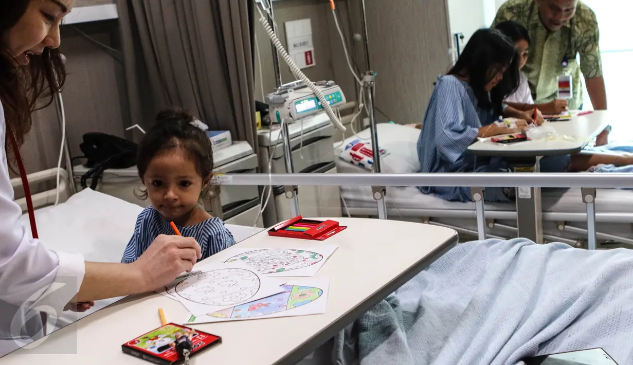 Seorang dokter membimbing pasien anak untuk mewarnai kertas bergambar telur Paskah di Rumah Sakit Siloam, Jakarta, Minggu (27/3). Kegiatan mewarnai gambar telur tersebut untuk menghibur pasien yang bertema "Stress Relief". (Liputan6.com/Fery Pradolo)