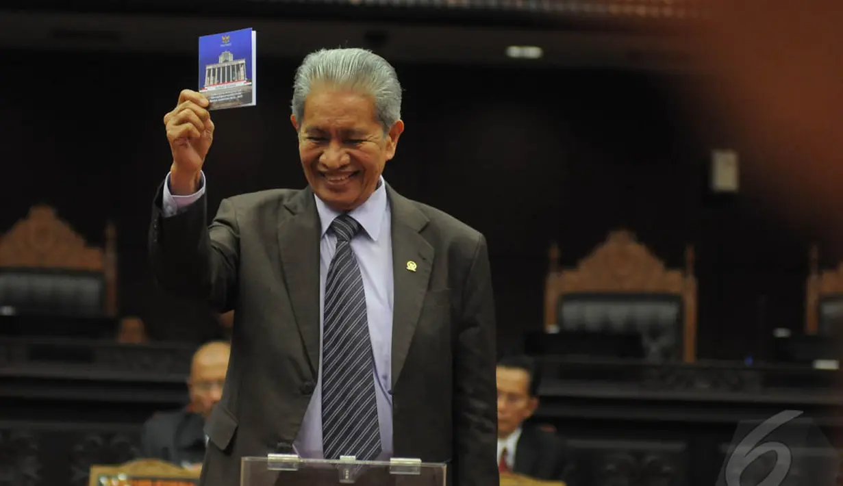 Hakim Konstitusi, Muhammad Alim saat menunjukkan kertas suara dalam pemilihan Ketua dan Wakil Ketua MK di Gedung MK, Jakarta, Senin (12/1/2015). (Liputan6.com/Herman zakharia)