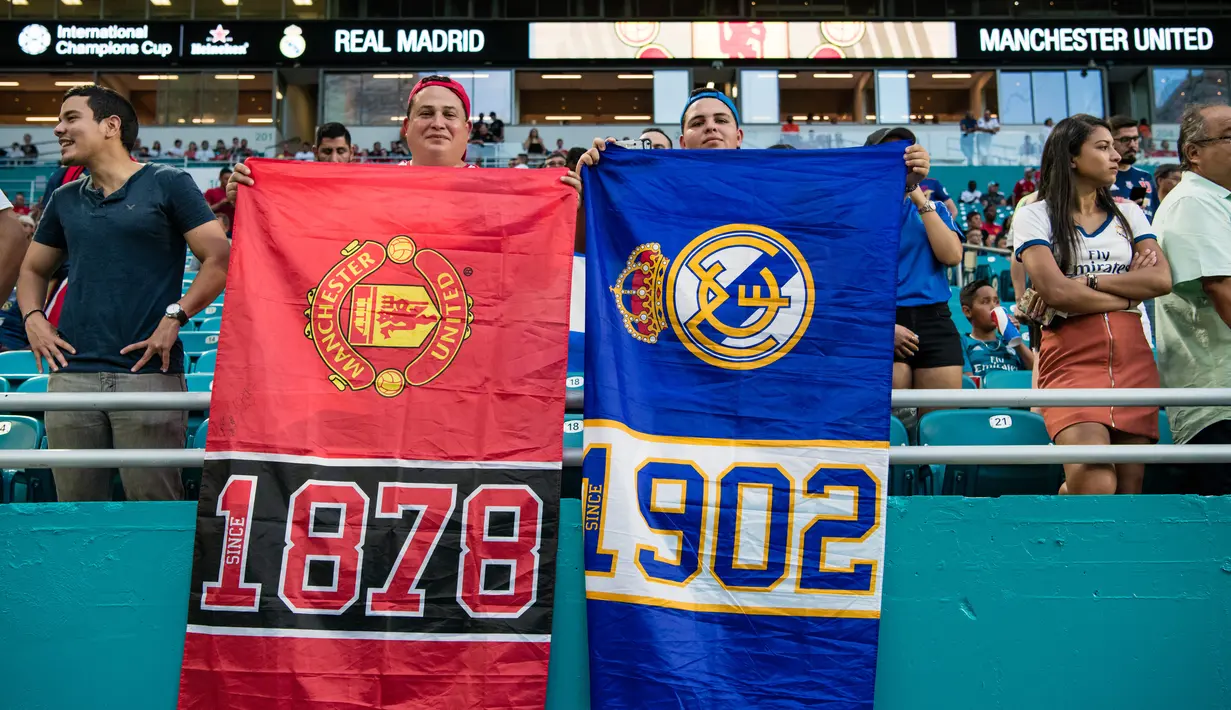 Suporter Manchester United dan Real Madrid membentangkan spanduk saat menyaksikan tim kesayangannya bertanding pada ICC 2018 di Miami Gardens, Fla (31/7). MU menang tipis 2-1 atas Madrid. (AFP Photo/Rob Foldy)