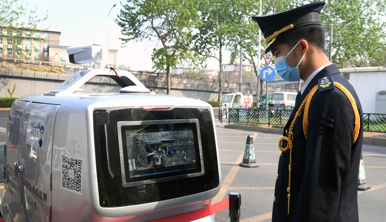 Petugas memeriksa mobil pengiriman tanpa awak di Institut Teknologi Beijing, Beijing, China, Senin (6/4/2020). Institut Teknologi Beijing menggunakan mobil pengiriman tanpa awak berteknologi 5G yang dapat mengukur suhu tubuh orang-orang yang memasuki kampus. (Xinhua/Ren Chao)