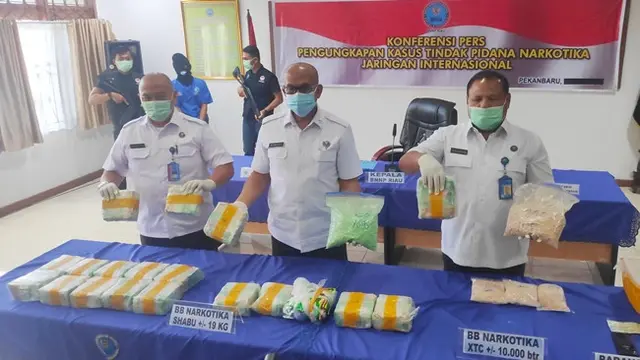 Petugas Badan Narkotika Nasional Provinsi Riau memegang barang bukti yang disita dari kurir sindikat internasional.