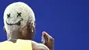 Rambut pelari Jamaika, Janieve Russell bergambar emoji wajah tersenyum saat berkompetisi dalam nomor lari gawang 400 meter Olimpiade Paris 2024 di Stade de France, Paris, Prancis, 6 Agustus 2024. (AFP/Jewel Samad)