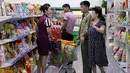 Pekerja berbincang dengan pelanggan di supermarket, Pyongyang, Korut (12/9). Banyak produk dalam negeri terlihat di rak-rak supermarket tersebut sebagai bagian dari upaya membangun ekonominya dan meningkatkan standar hidup nasional. (AP Photo/Kin Cheung)