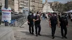 Polisi anti huru-hara Prancis mengamati warga yang mengenakan masker di Marseille, Selasa (18/8/2020). Pemerintah Prancis mengirim polisi anti huru hara ke wilayah Marseille untuk membantu menegakkan peraturan penggunaan masker saat negara itu mencatat lonjakan kasus COVID-19. (AP Photo/Daniel Cole)
