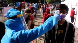 Petugas menggukur suhu warga yang akan mengikuti rapid test massal di Kota Tangerang, Banten, Sabtu (30/5/2020).  Badan Intelijen Negara (BIN) menggelar tes diagnostik cepat (rapid rest) massal kepada warga Ciledug sebagai salah satu upaya pengendalian transmisi COVID-19. (Liputan6.com/Angga Yuniar)