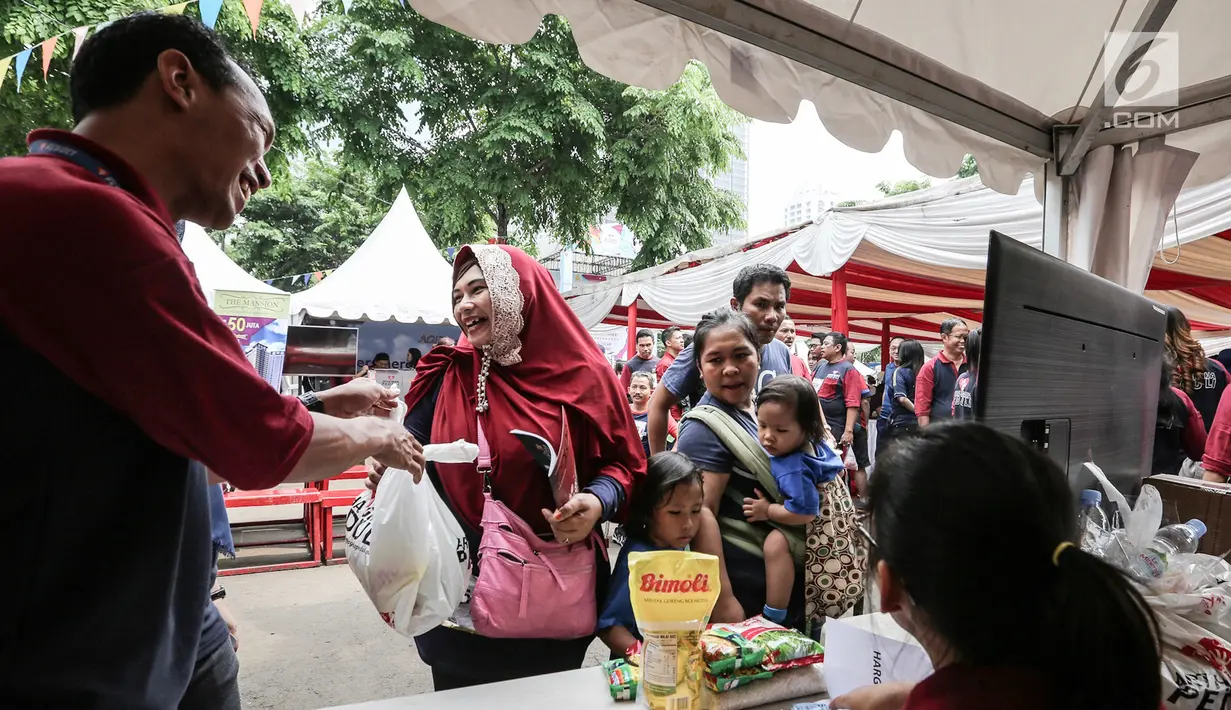 Warga membeli sembako murah pada acara Family Day Artha Graha Peduli (AGP) di Pasar Akhir Pekan SCBD, Jakarta, Minggu (25/11). Acara ini juga melibatkan UMKM binaan serta berbagai hiburan dan permainan. (Liputan6.com/Fery Pradolo)