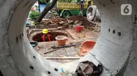 Pekerja saat membuat lubang untuk sumur rasapan di Jalan Kebon Jeruk, Jakarta Barat, Jumat (15/10/2021). Hingga saat ini, Pemprov DKI Jakarta sudah membuat sumur resapan di 6.233 titik. (Liputan6.com/Johan Tallo)