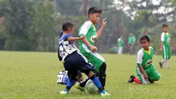 Seorang kontestan MILO Road to Barcelona menghalau bola dari lawannya pada laga latih tanding di International School Clubs of Indonesia, Cirendeu, (15/7/2017). (Bola.com/Nicklas Hanoatubun)