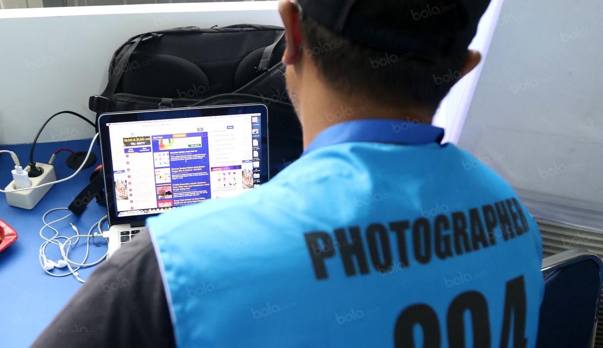Seorang Fotografer sedang mengirimkan hasil foto saat meliput turnamen Indonesia Open 2016 di Istora Senayan, Jakarta. (Bola.com/Nicklas Hanoatubun)