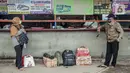 <p>Sejumlah calon penumpang berdiri di depan loket Terminal Bayangan Lebak Bulus, Jakarta, Kamis (21/4/2022). Sebagian pemudik memilih pulang kampung lebih awal untuk menghindari puncak arus mudik yang diperkirakan dimulai pada H-5 dan H-3 Lebaran 2022. (Liputan.com/Faizal Fanani)</p>