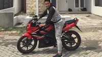 Andik Vermansah dengan motor Honda CBR 150R di depan rumahnya di kawasan elite Surabaya. (Bola.com/Zaidan Nazarul)