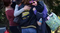Orang tua dan siswa berpelukan di dekat Franklin Regional High School setelah lebih dari selusin siswa ditikam oleh tersangka yang memegang pisau di sekolah di Murrysville, Pa., 9 April 2014. (AP)