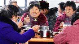 Orang-orang menikmati makanan gratis di kantin untuk warga lanjut usia (lansia) di Desa Yingshan, Kota Quanzhou, Provinsi Fujian, China pada 17 Desember 2020. Kantin tersebut didirikan untuk memberikan makanan gratis kepada warga berusia 60 tahun ke atas yang tinggal sendiri. (Xinhua/Wei Peiquan)