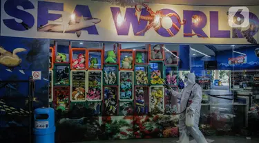 Petugas mengenakan pakaian pelindung menyemprotkan disinfektan area Sea World, Ancol, Jakarta, Sabtu (14/3/2020). Pembersihan Sea World dan Ocean Samudera guna mengantisipasi penyebaran virus corona (Covid-19). (Liputan6.com/Faizal Fanani)