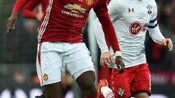 Gelandang Manchester United, Paul Pogba berusaha menggiring bola dari kejaran gelandang Steven Davis pada final Piala Liga Inggris di Stadion Wembley, London, (27/2). MU menang atas Southampton dengan skor 3-2. (AFP Photo / Glyn Kirk)