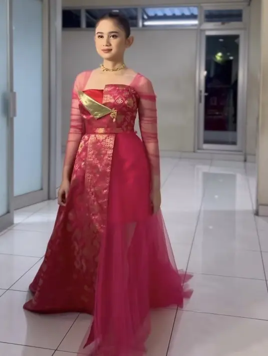 Tissa Biani tampil dengan dress pink, dengan aksen lengan transparan dan kain songket khas Bali. Baju tersebut dibuat oleh Jacob William. [@tissabiani]