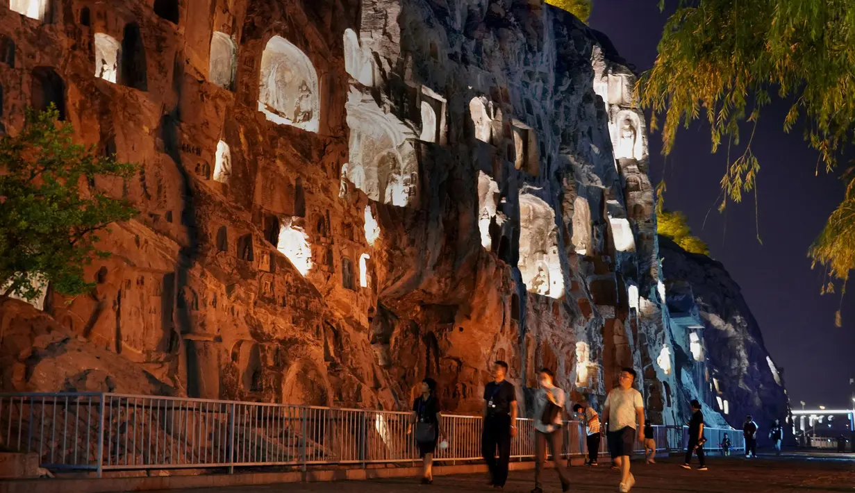Sejumlah wisatawan mengunjungi Gua Longmen, sebuah lokasi wisata berpanorama menawan di Luoyang, Provinsi Henan, China tengah, pada 7 Juli 2020. Berbagai bentuk tur malam hari di Luoyang menarik banyak wisatawan dan mendongkrak perekonomian. (Xinhua/Li An)