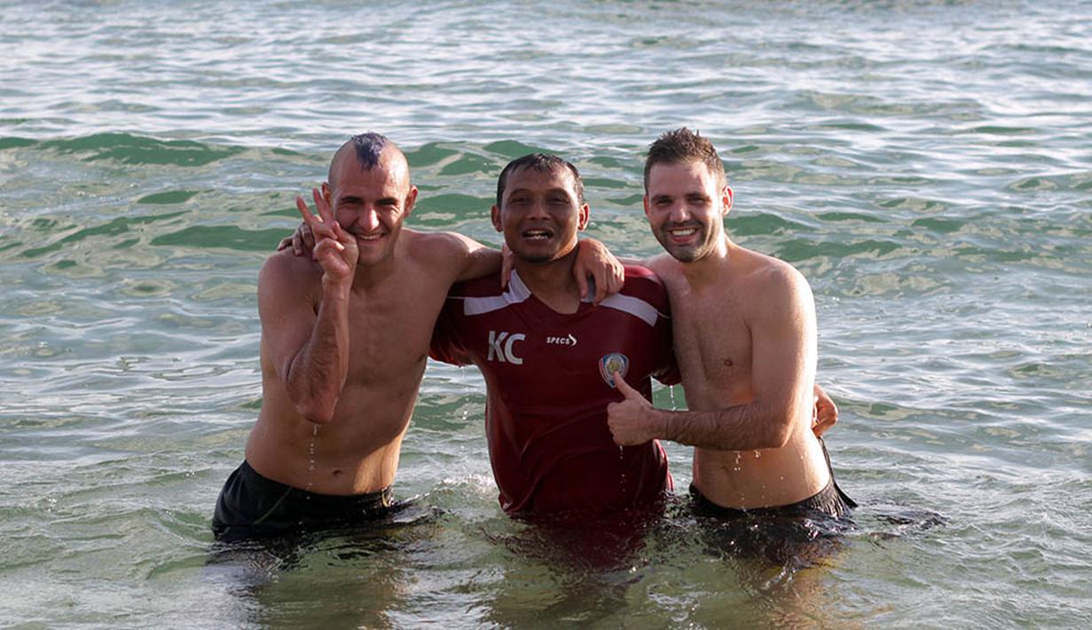 Asisten pelatih Arema Cronus, Kuncoro, foto bersama dua bintang asal Spanyol, Kiko Insa dan Toni Mosi usai latihan fisik di Pantai Balekambang, Malang. (Bola.com/Kevin Setiawan)