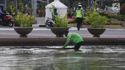 Petugas membersihkan busa yang mencemari kolam air mancur di bundaran patung kuda, Jakarta, Rabu (28/3). Petugas masih menyelidiki asal busa tersebut. (Liputan6.com/Arya Manggala)