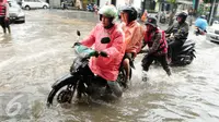Seorang petugas membantu mendorong sepeda motor yang menerobos banjir di kawasan Kemang, Jakarta, Selasa (4/10). Hujan deras yang mengguyur Jakarta dan meluapnya kali Krukut menyebabkan wilayah Kemang kembali terendam banjir. (Liputan6.com/Gempur M Surya)
