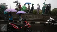 Warga menonton Jembatan Penyeberangan Orang (JPO) yang roboh akibat hujan deras dan angin kencang di Jalan Raya Pasar Minggu, Jakarta Selatan, Sabtu (24/09). Petugas masih memotong bagian JPO tersebut. (Liputan6.com/Immanuel Antonius)