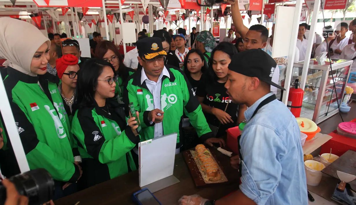 Menhub Budi Karya, Chief Corporate Affairs GOJEK Nila Marita, dan aktris Okky Asokawati mengunjungi salah satu merchant pada acara GO-FOOD Festival di Depok, Sabtu (5/1). (Liputan6.com/HO/Ading)