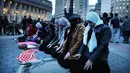 Sejumlah wanita muslim terlihat khusuk saat menggelar salat berjemaah sebelum melakukan aksi protes di Manhattan, New York (1/2). Mereka mengecam kebijakan Donald Trump terkait larangan imigran dari negara mayoritas muslim masuk ke AS. (AFP/Spencer Platt)