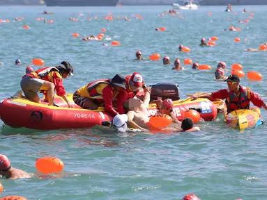 Petugas penyelamat mengangkat seorang perenang dari air dalam keadaan tidak sadar saat mengikuti lomba renang lintas pelabuhan berjarak 1.500 meter di Hong Kong, Minggu (16/10). Perenang itu tewas saat dilarikan ke rumah sakit. (REUTERS/APPLE DAILY)