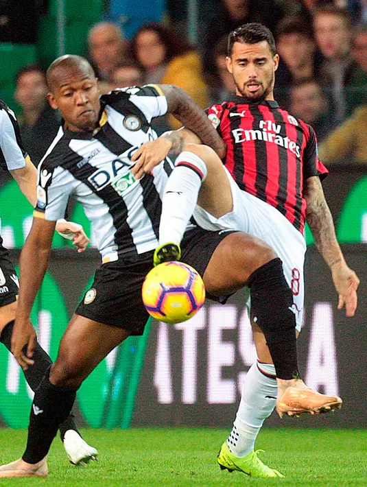 Gelandang AC Milan, Suso berebut bola dengan bek Udinese, Santos Samir saat bertanding di Liga Italia di stadion Friuli Dacia Arena, Italia (4/11). Milan menang dramatis 1-0 berkat gol tunggal Alessio Romagnoli jelang akhir laga. (AP Photo/Sefano Lancia)