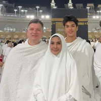 Maudy memilih umrah di penghujung tahun 2024 bersama suami dan putranya. Tampak keluarga ini pun berfoto di depan Ka'bah dengan pakaian serba putih. [@maudykoesnaedi]