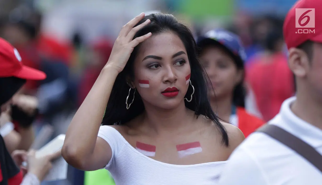 Salah satu pendukung tim Indonesia bersiap menyaksikan seremoni pembukaan Asian Games 2018 di Stadion GBK, Jakarta, Sabtu (18/8). Asian Games 2018 akan berlangsung hingga 2 September, mendatang. (Liputan6.com/Helmi Fithriansyah)