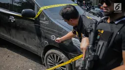 Petugas kepolisian menunjukkan barang bukti mobil yang digunakan tersangka kasus narkotika jaringan Internasional Malaysia-Indonesia di Polres Jakarta Barat, Selasa (16/7/2019). Polisi berhasil mengamankan Empat tersangka. (Liputan6.com/Faizal Fanani)