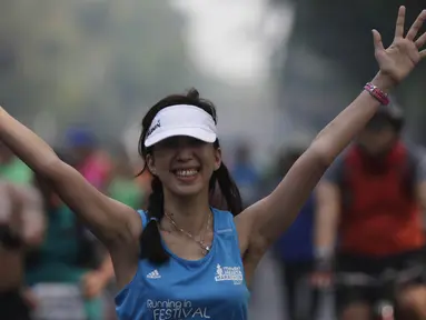 Peserta Mandiri Jakarta Marathon 2015 tampak ceria saat berlari menuju finish di halaman Monumen Nasional, Minggu (25/10/2015). (Bola.com/Vitalis Yogi Trisna)