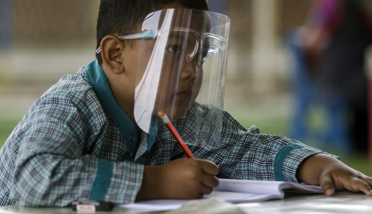 Siswa SD memkai pelindung wajah saat pembelajaran tatap muka di Sekolah Islam Ibnu Aqil Ibnu Sina, Soreang, Bandung, Jawa Barat, Rabu (5/8/2020). Indonesia akan mengizinkan sekolah di zona hijau COVID-19 melakukan pembelajaran tatap muka di bawah protokol kesehatan yang ketat. (Xinhua/Septianjar)