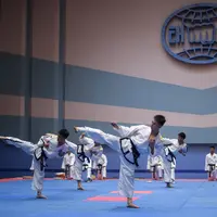 Peserta melakukan tendangan selama demonstrasi taekwondo sebagai bagian dari Kejuaraan Seni Bela Diri Nasional tahunan Mangyongdae di 'Taekwon-Do Hall' di Pyongyang, Korea Utara (9/11). (AFP Photo/Kim Won Jin)