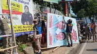 Petugas Satuan Polisi Pamong Praja (Satpol PP) Kota Bogor dikerahkan untuk menurunkan alat peraga kampanye (APK) secara serentak di sejumlah wilayah Kota Bogor, Minggu (11/2/2024). (Liptutan6.com/Achmad Sudarno).