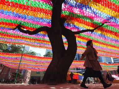 Pengunjung melihat lampion yang terpasang di Jogye Temple jelang perayaan ulang tahun Buddha, Seoul, Rabu (12/4). ‘Lotus Lantern Festival’ menjadi salah satu perayaan yang ditunggu-tunggu oleh warga Korea Selatan. (AFP PHOTO / JUNG Yeon-Je) 